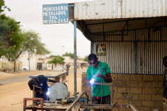 Ameth et Moussa sont deux équipementiers. Ils travaillent à la fabrication d’un torréfacteur d’arachide pour la PME Kadior. Travail en atelier / achat de pièces chez le quincailler / maintenance de l’équipement chez Kadior / test sur la plateforme Biomasse Energie de Biostar.